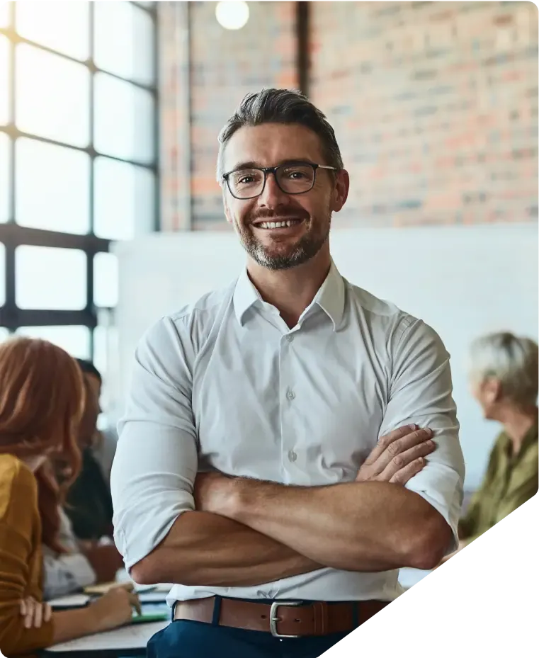 Smiling adviser in glasses and a white shirt in front of colleagues in a meeting room