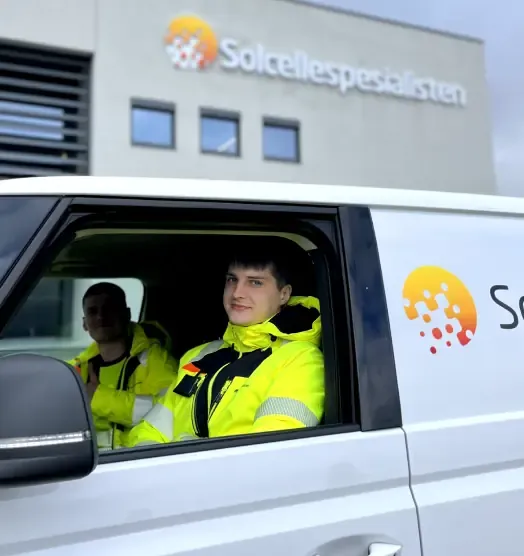 Two installers in yellow work jackets in one of Solcellespesialisten’s service vans
