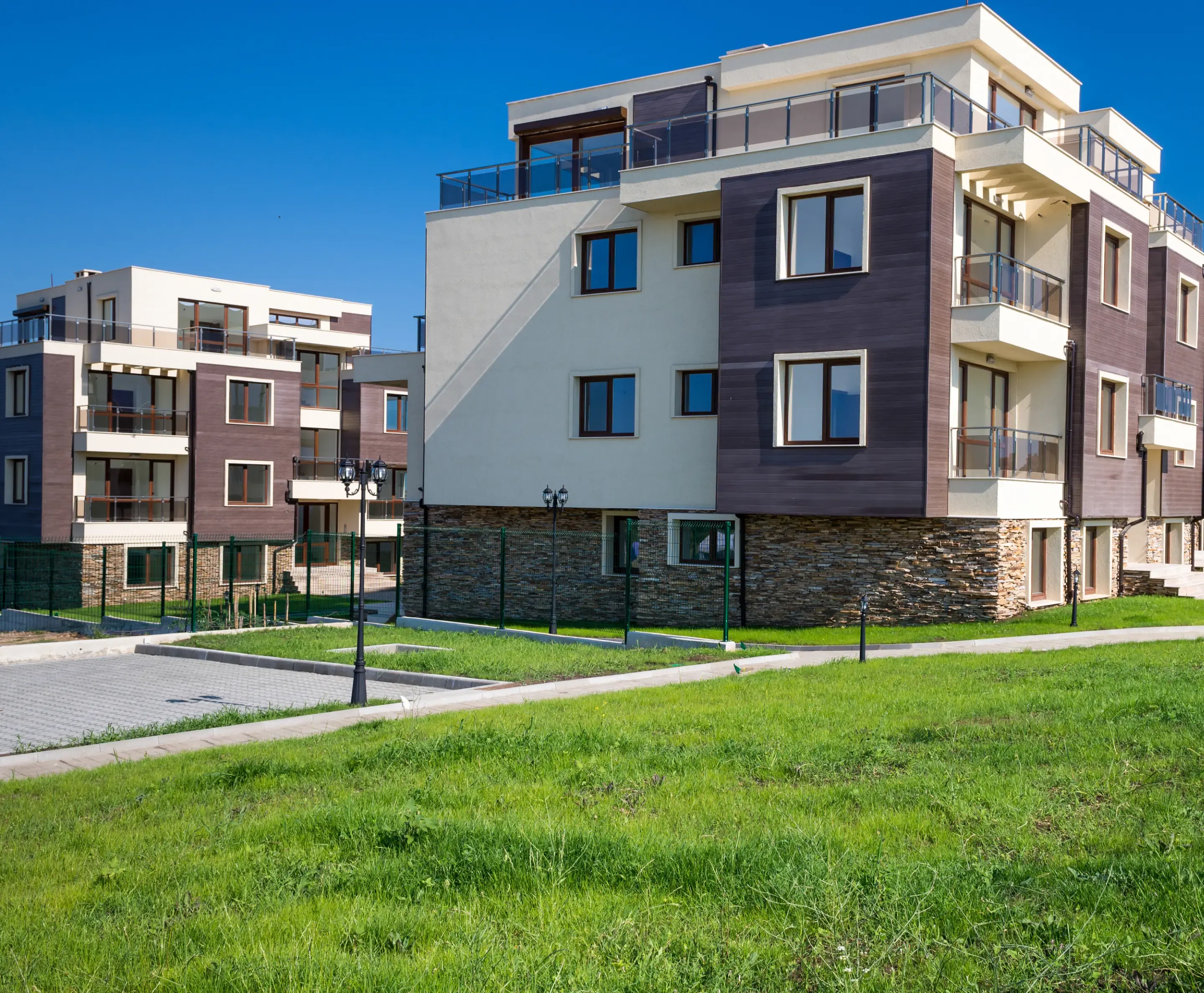Newer apartment blocks with balconies and green outdoor areas on a sunny day